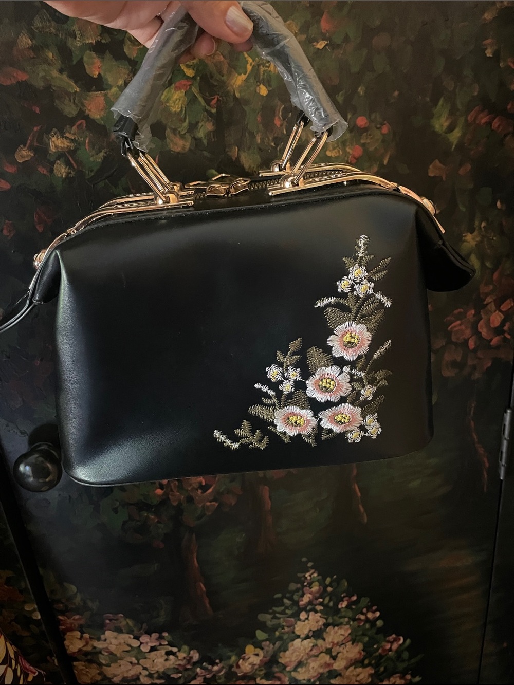 Black faux-leather doctor-style handbag featuring delicate floral embroidered